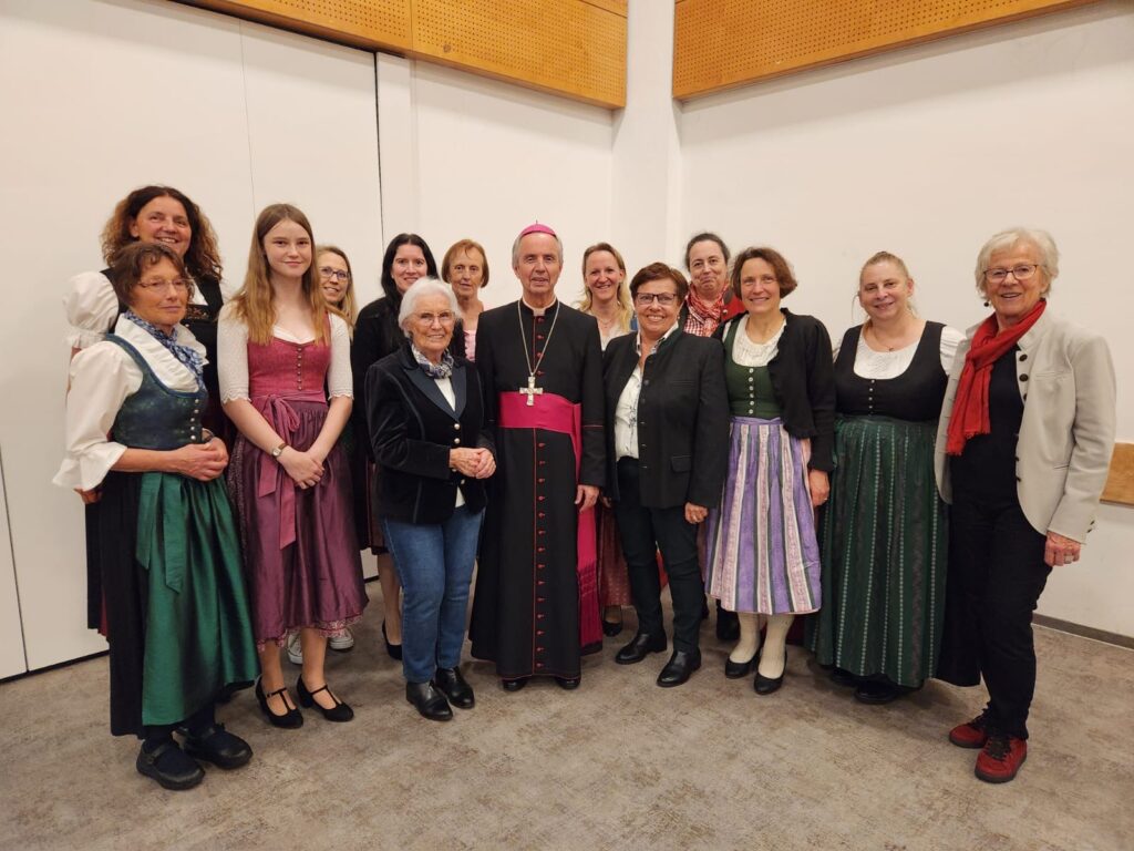 Gruppenbild, Bischof und 13 Sängerinnen in Tracht