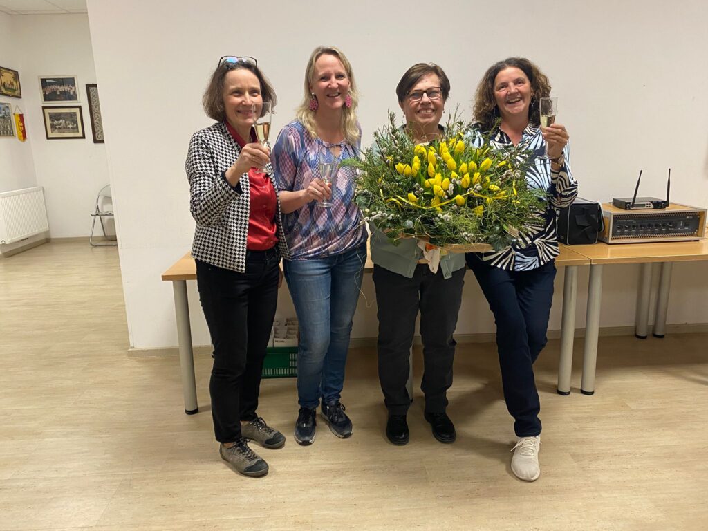 Obfrauen, Chorleiterin und Jubilarin mit Blumenstrauß